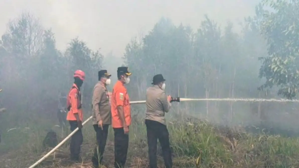 Kapolda Kalimantan Selatan Irjen Pol Rosyanto Yudha Hermawan memimpin pemadaman karhutla di lahan kosong sekitar Bandara Internasional Syamsudin Noor di Banjarbaru, Sabtu (22/8). (ANTARA/Firman)