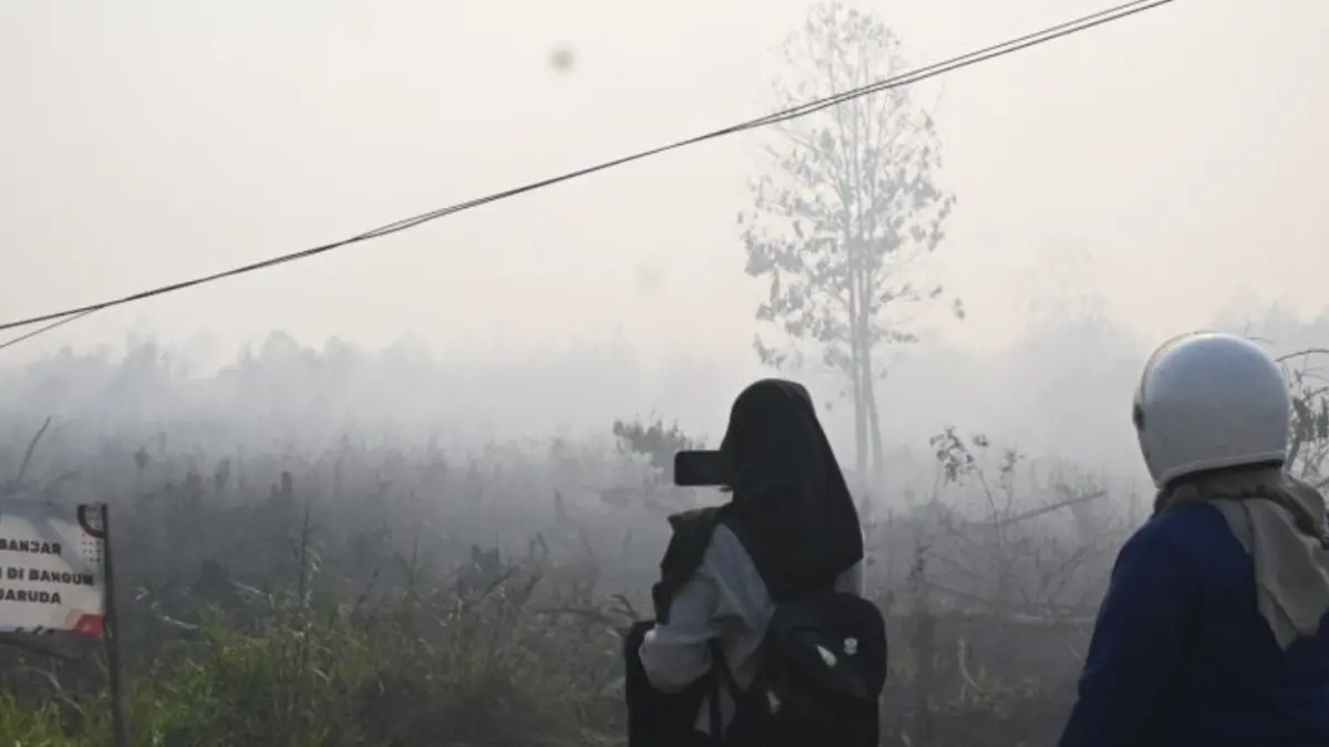 Sejumlah orang mengabadikan foto kondisi lahan yang dikepung kabut asap akibat kebakaran hutan dan lahan (karhutla) di Syamsudin Noor, Banjarbaru, Kalimantan Selatan, Sabtu (22/8). (ANTARA/Tumpal Andani Aritonang)