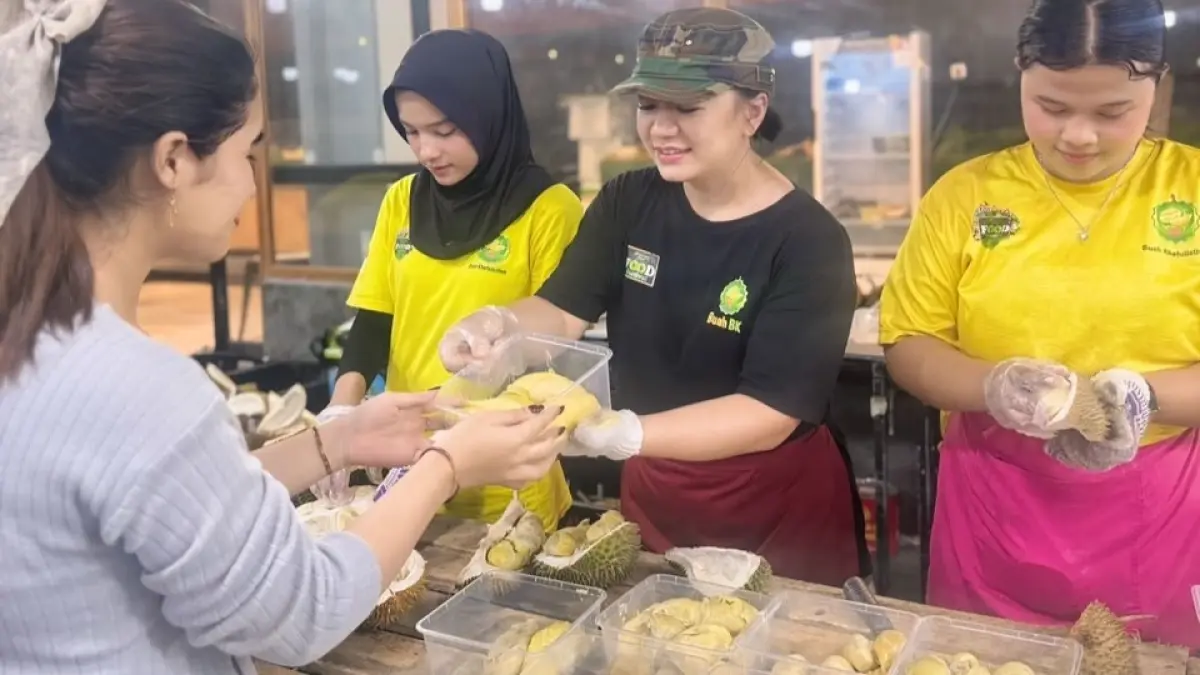 LAYANI KONSUMEN: Yenna melayani konsumen yang memilih durian Balai Karangan di BK Store, Pontianak. Durian lokal asal Kabupaten Sanggau itu dihadirkan untuk mengenalkan kekayaan cita rasa buah Kalimantan Barat. (RAMSES/PONTIANAK POST)