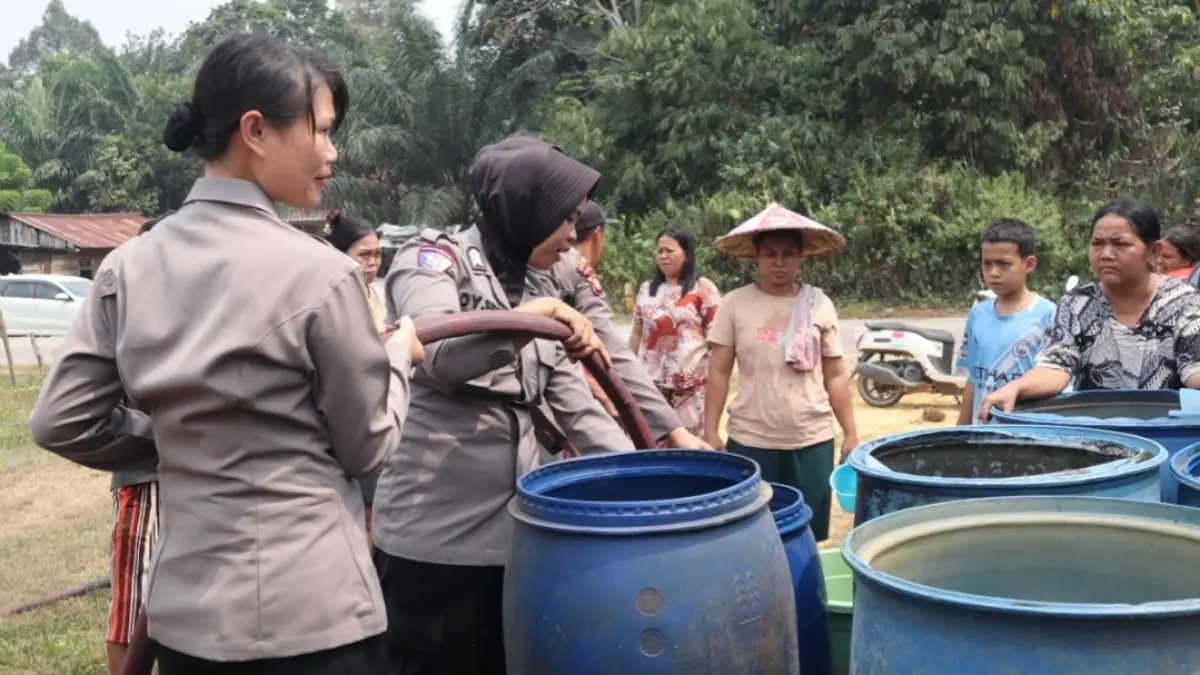 Polwan Polres Sekadau membantu warga mengisi wadah air bersih dalam penyaluran 18 ribu liter air untuk masyarakat terdampak kemarau di Kecamatan Sekadau Hilir, Senin (24/8/2026).