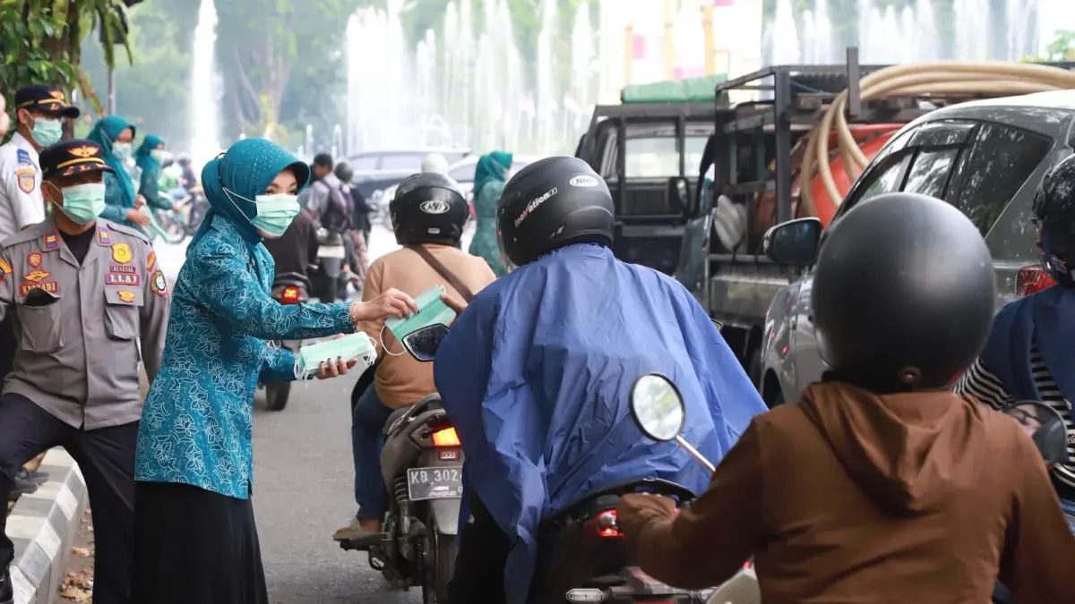 Pembagian masker kepada pengguna jalan di tengah kabut asap. (ISTIMEWA)