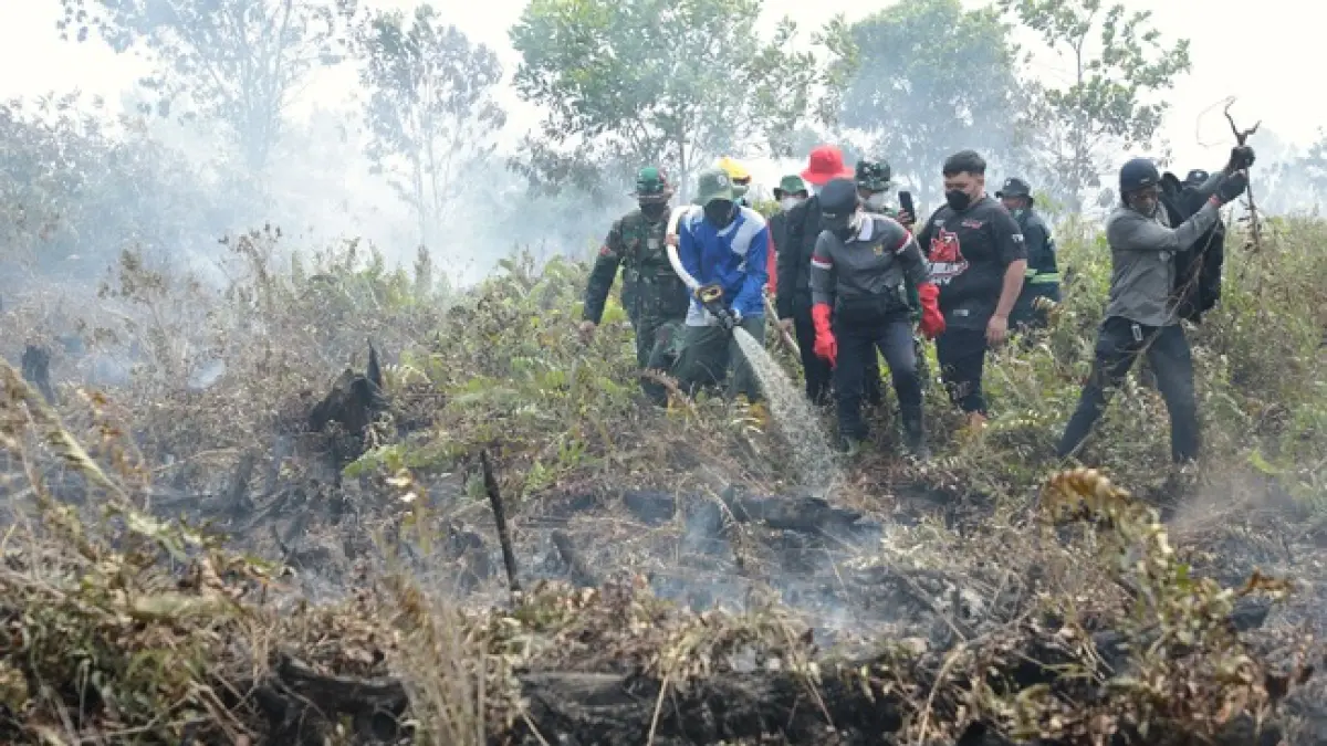 Petugas berupaya memadamkan kebakaran lahan di sekitar Jembatan 12, akses masuk Bandara Singkawang, Kelurahan Pangmilang, Singkawang Selatan, Selasa (25/8).
