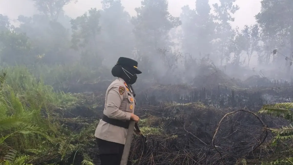 Kepolisian saat berupaya melakukan pembasahan lahan gambut di i Jalan Aloevera, Kompleks RBK 7, Kelurahan Bansir Darat, Kecamatan Pontianak Tenggara, yang terbakar pada Rabu (26/8). (ISTIMEWA)