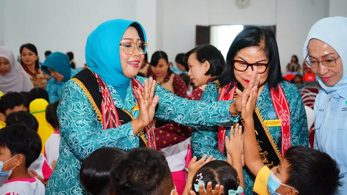 Ketua Umum Forum Peningkatan Konsumsi Ikan (Forikan) Provinsi Kalbar, Erlina Norsan dan Wakil Ketua Dekranasda Provinsi Kalbar Donata Dirasig Krisantus Kurniawan sedang berinteraksi dengan anak-anak saat kunjungan kerja ke Kabupaten Landak. (Adpim Pemprov Kalbar)