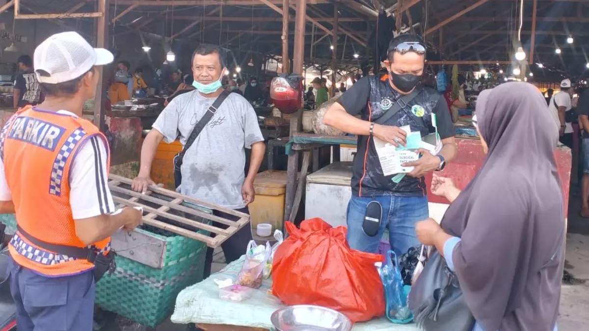 Anggota AJK membagikan masker ke sejumlah pedagang di sejumlah pasar tradisional di Kota Ketapang, Selasa (1/9). (ISTIMEWA)