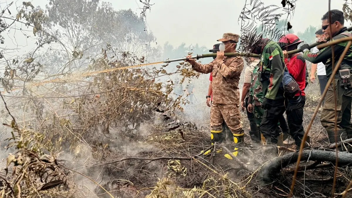 Gubernur Kalbar Ria Norsan turun langsung menyemprot titik api di Sekunder C Kecamatan Rasau Jaya Kabupaten Kubu Raya pada Rabu (2/9). (MEIDY KHADAFI/PONTIANAK POST)