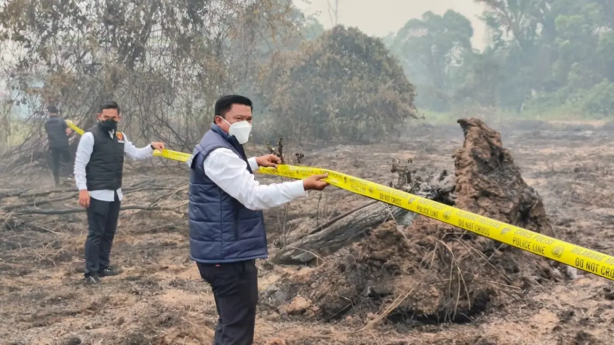 Petugas memasang garis polisi di lahan bekas terbakar di kawasan Lintang Batang, Jalan Trans Kalimantan, Desa Teluk Bakung, Kecamatan Sungai Ambawang.