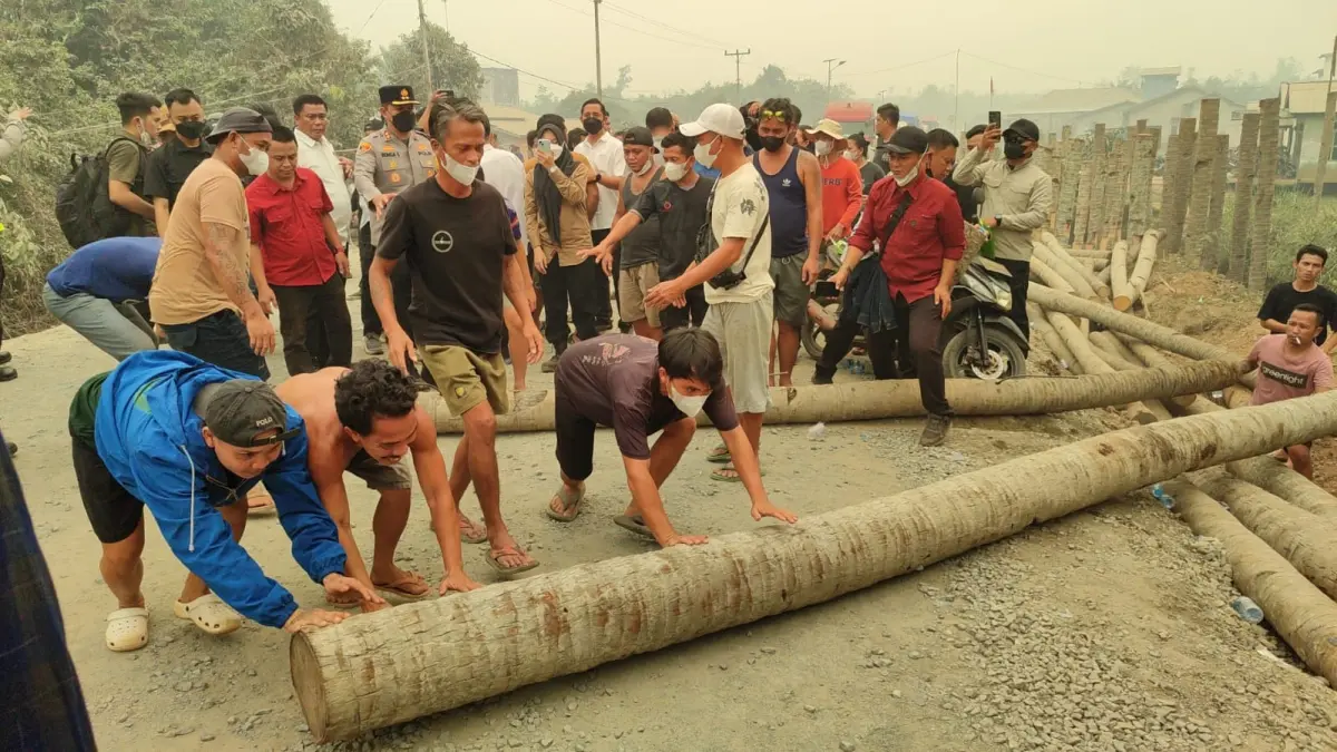 Warga setempat memblokade jalan trans kalimantan KM 37,5 di Dusun Tapah Desa Pancaroba Kecamatan Sungai Ambawang Kabupaten Kubu Raya pada Rabu (2/9). Mereka mengeluhkan debu pengerjalan jalan yang melintas rumah mereka. (ISTIMEWA)