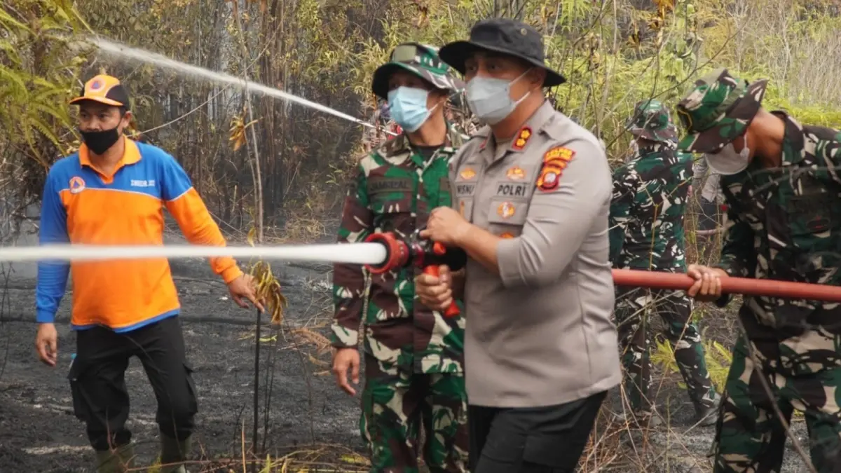 Kapolres Kapuas Hulu saat ikut melakukan pemadaman Karhutla yang terjadi Dusun Senai, Desa Tani Makmur, Kecamatan Hulu Gurung yang diduga masuk dalam kawasan PT BOS. (ISTIMEWA)