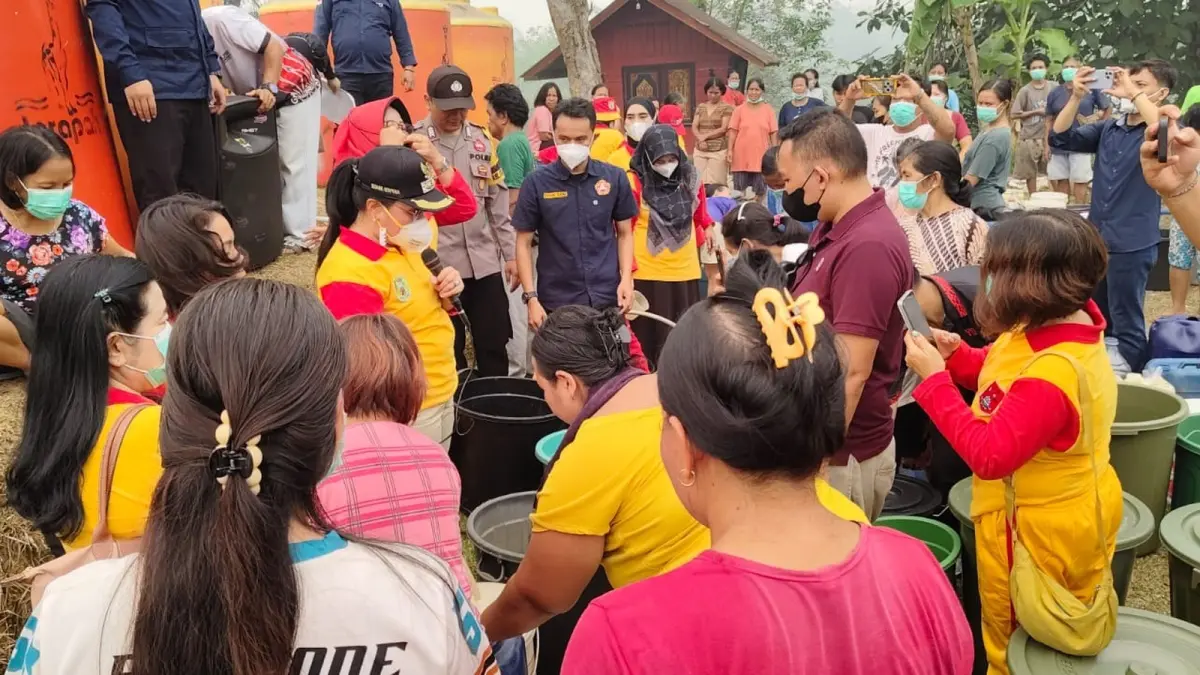 Ketua GOW Kabupaten Sanggau yang juga Wakil Bupati Sanggau, Susana Herpena (memegang mikrofon), mendistribusikan bantuan air bersih kepada warga RT 11 Segole, Kelurahan Tanjung Kapuas, Jumat (4/9). (AGUNG RAJALI SAPUTRA/PONTIANAK POST)