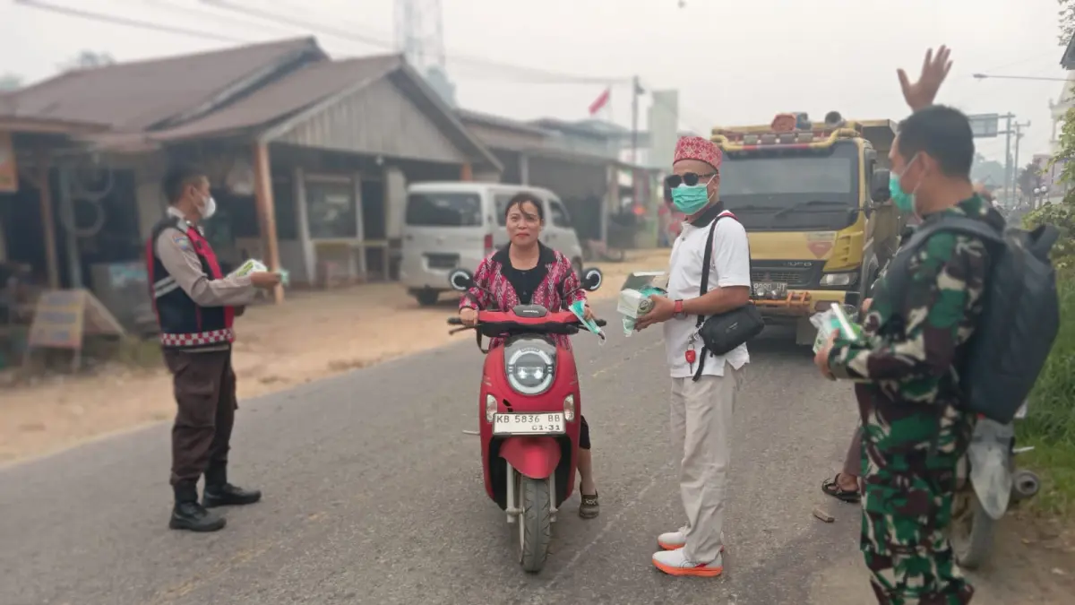 Ketua DAD Kecamatan Toho, Alpian memimpin pembagian masker.