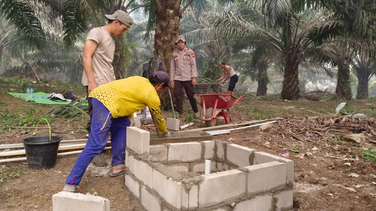 Personel Polsek Meranti bersama warga Dusun Jelayan membangun sumur bor di titik rawan karhutla pada Kamis (3/9). 