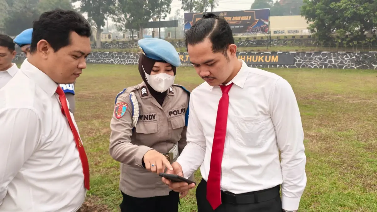 PERIKSA PONSEL: Petugas Sipropam Polres Landak memeriksa ponsel anggota seusai apel, Senin (7/9). Pemeriksaan dilakukan untuk mencegah keterlibatan personel dalam judi online.
