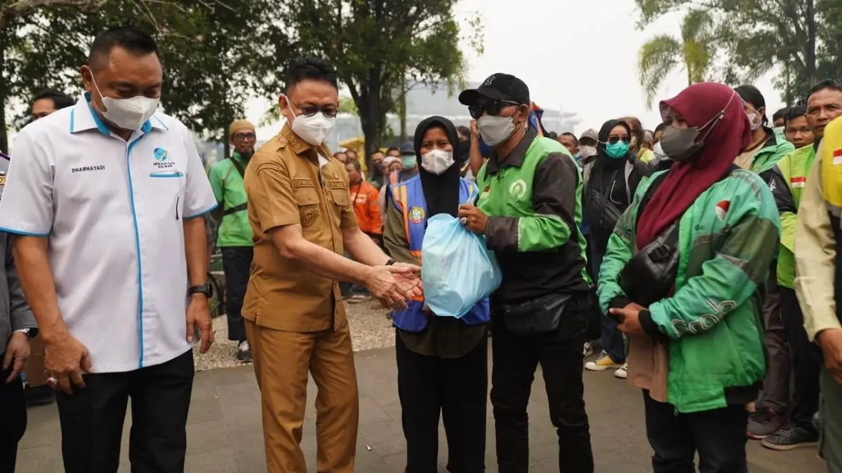 Wali Kota Pontianak Edi Rusdi Kamtono menyerahkan paket bantuan sembako dari Insan Maritim Peduli kepada pengemudi ojek online dan warga di Taman Alun Kapuas, Pontianak, Selasa (8/9/2026). (Prokopim)