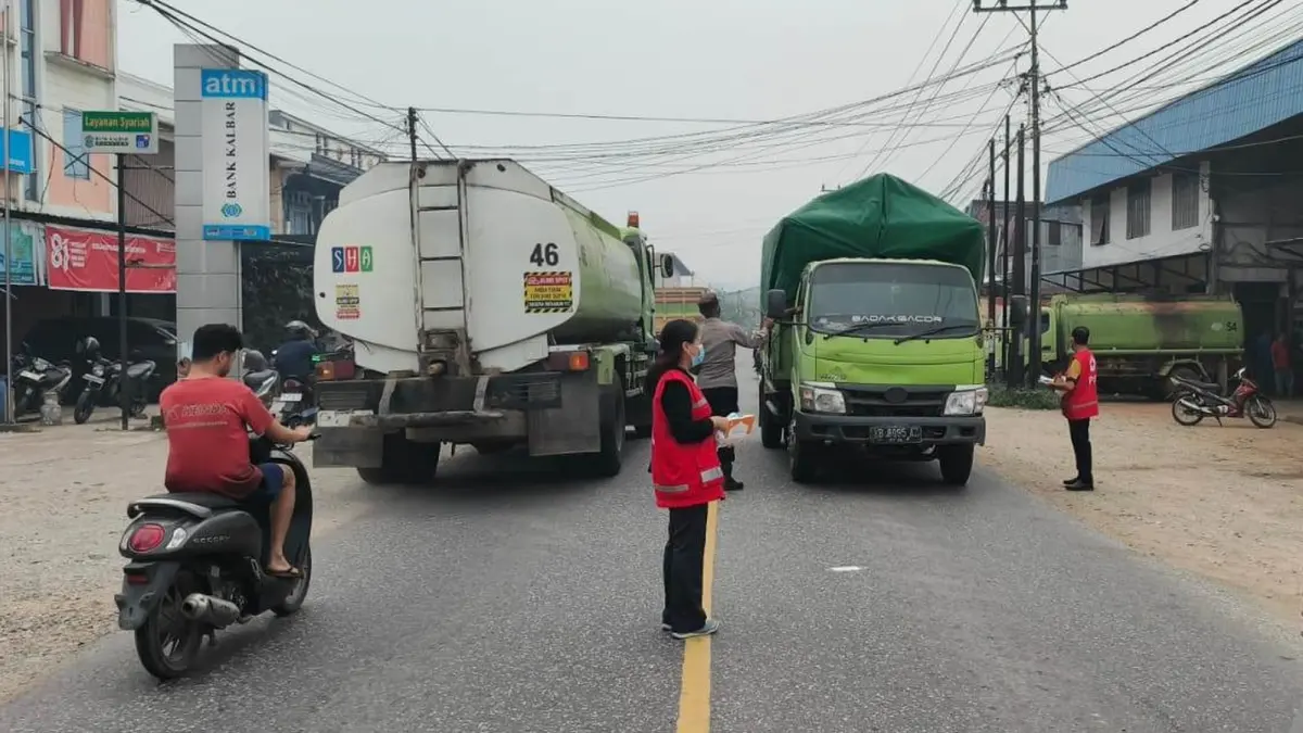 Petugas gabungan bersama relawan PMI Tayan Hulu membagikan masker kepada pengendara yang melintas di Jalan Raya Sosok, Kecamatan Tayan Hulu, Kabupaten Sanggau, Selasa (8/9). (ISTIMEWA)