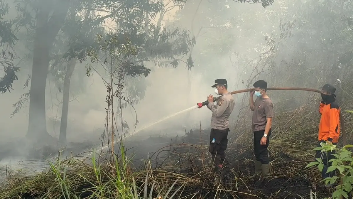Petugas melakukan pendinginan di lahan bekas kebakaran di Jalan Madusari, Desa Limbung, karena bara masih ditemukan di bawah lapisan gambut. (ISTIMEWA)