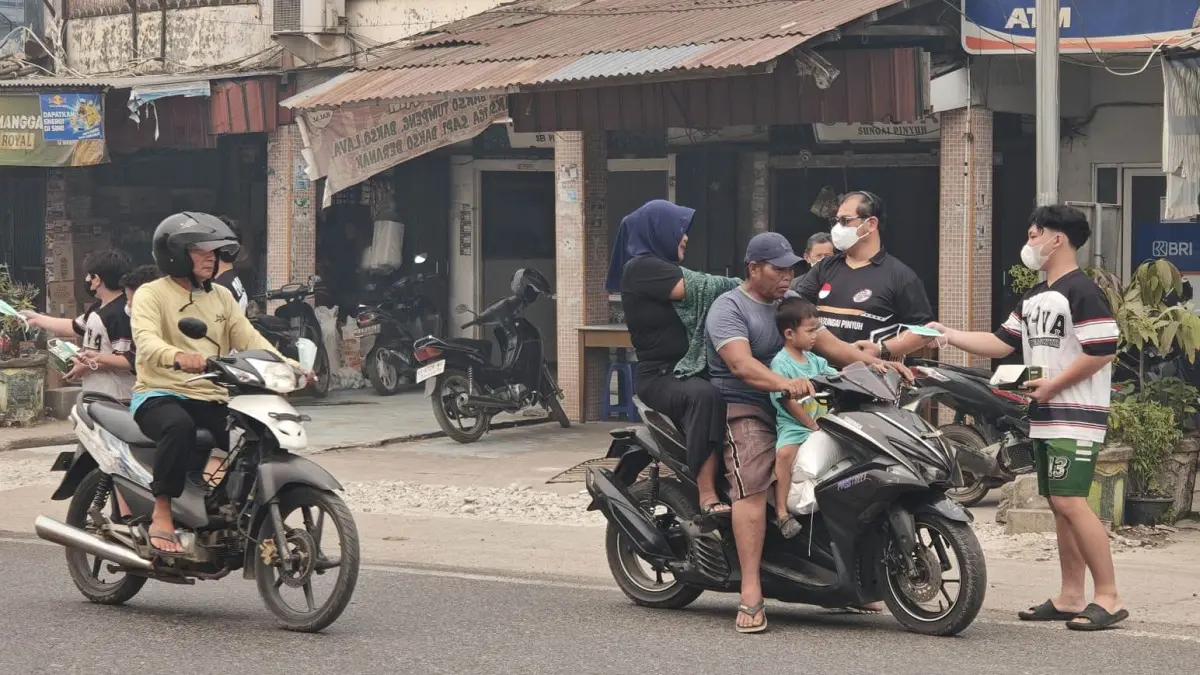 Pemadam dan Polsek Sungai Pinyuh bagikan masker kepada pengendara.
