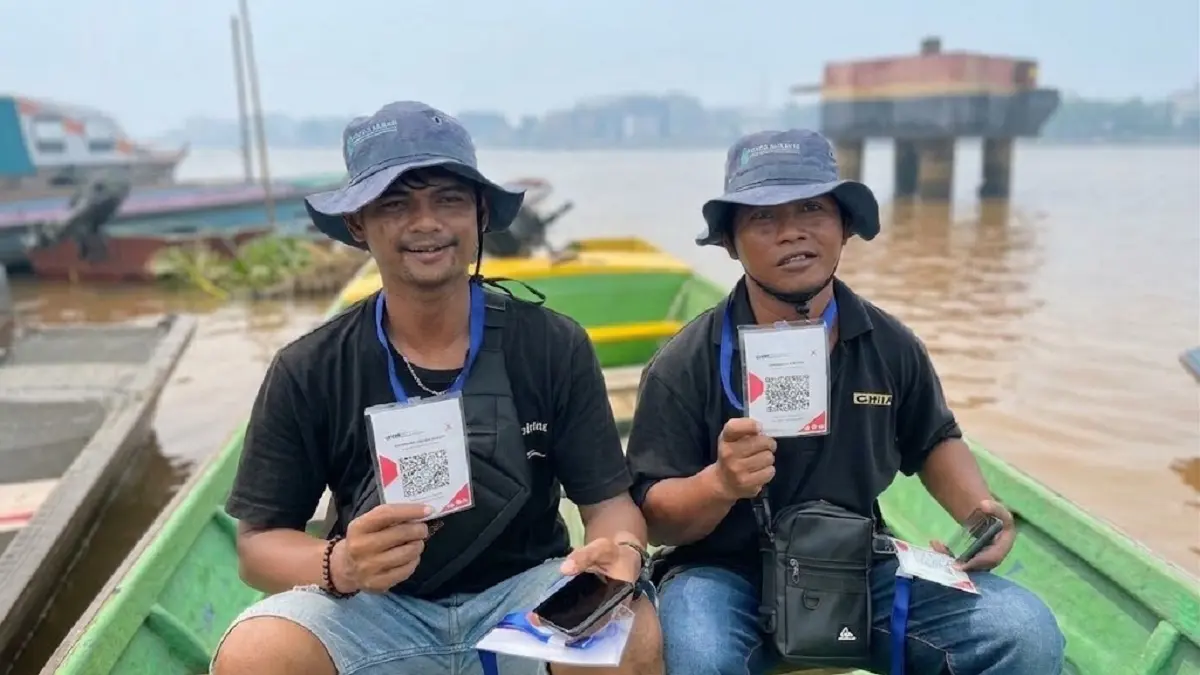 Para penambang memperlihatkan kode QRIS yang digunakan penumpang untuk membayar ongkos penyeberangan secara nontunai. (RAMSES/PONTIANAK POST)