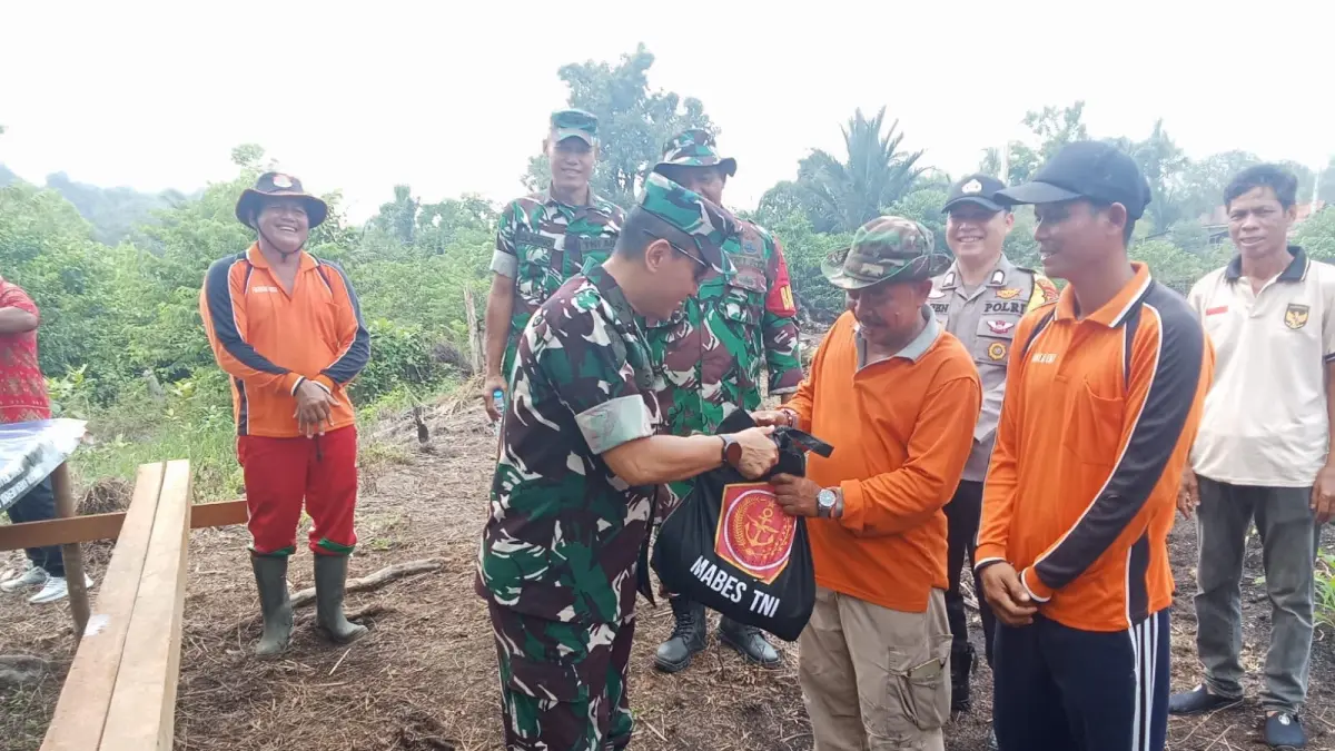Tim Penyuluh Karhutla dari Mabes TNI, Brigjen TNI Sain Mustain, didampingi Danpos Ramil Putussibau Utara Peltu Diaz, menyerahkan bantuan berupa bingkisan kepada warga terdampak Karhutla.(ISTIMEWA)
