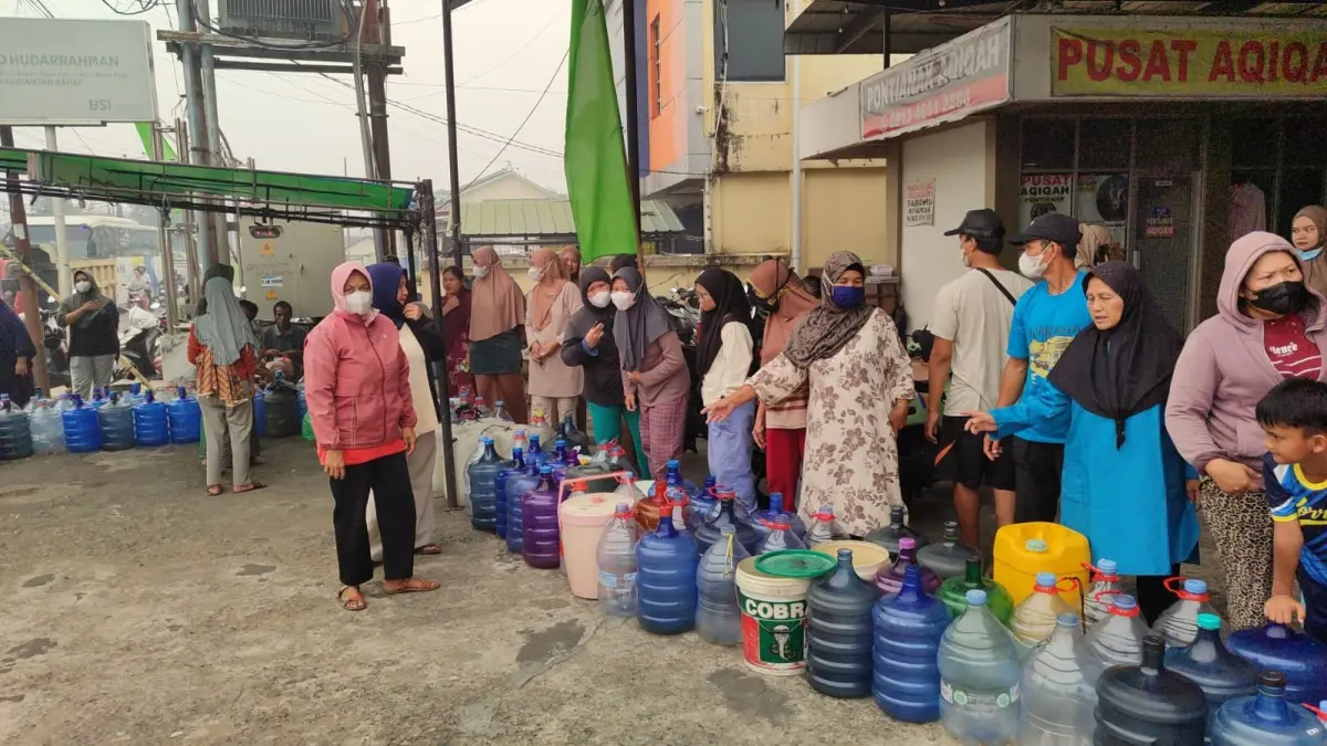 Warga Dusun Parit Mayor, Desa Kapur, menerima bantuan air bersih yang disalurkan Polres Kubu Raya bersama Pemkab Kubu Raya, Minggu (13/9). 
(ISTIMEWA)