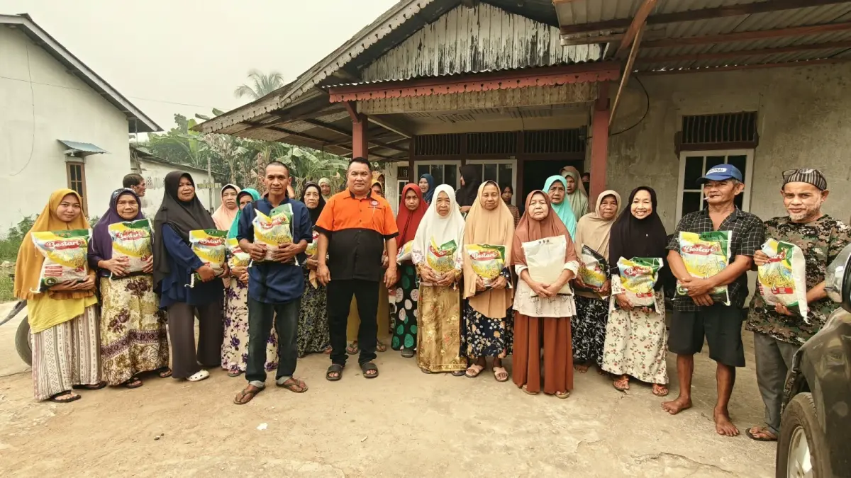 Ketua Pemadam Kebakaran Jaguar Sungai Pinyuh diabadikan bersama warga saat pembagian beras sebanyak 1 ton.