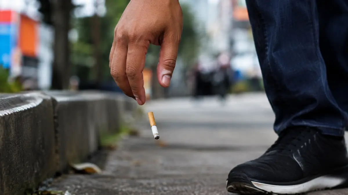 Ilustrasi - Membuang puntung rokok sembarangan.
