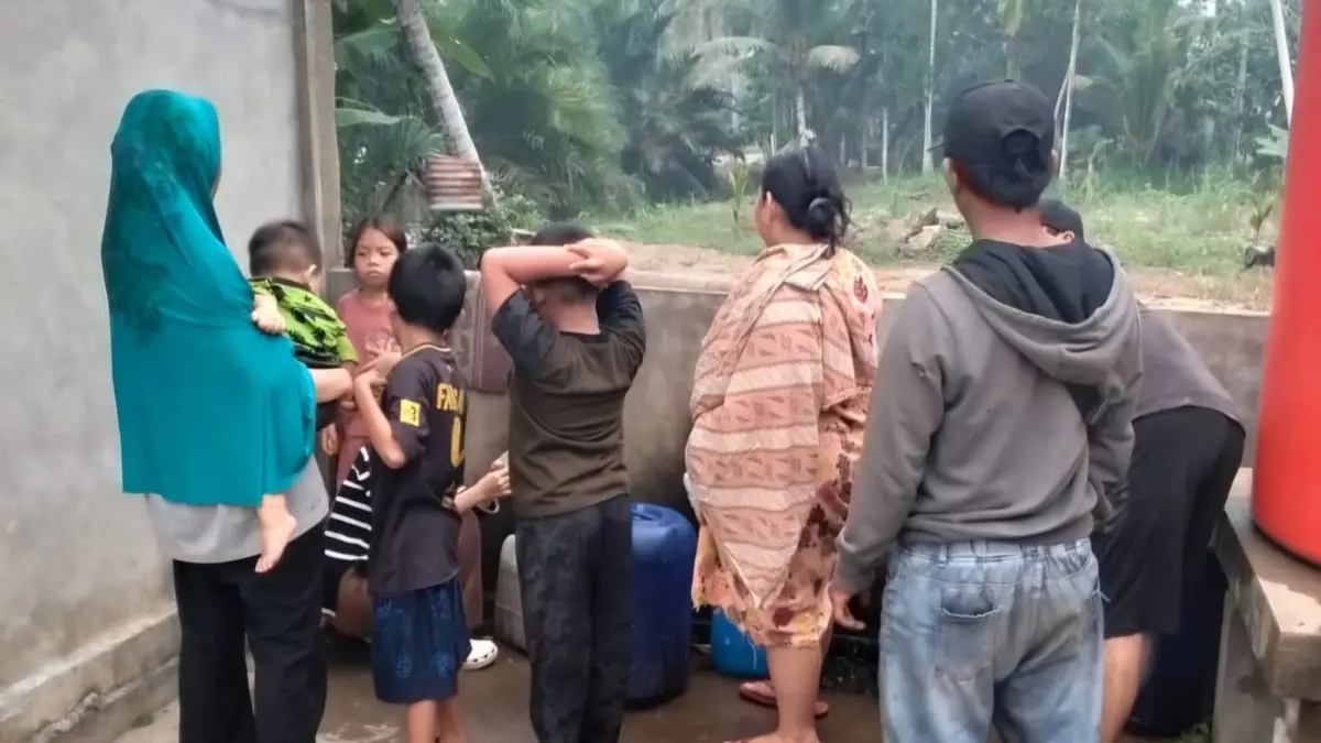 Warga Sungai Sahang mengisi air bantuan dari pemadam Jaguar.