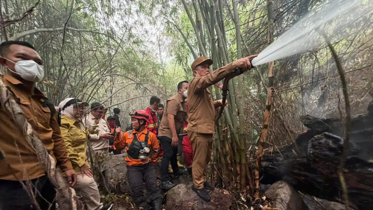 PADAMKAN API: Gubernur Kalimantan Barat Ria Norsan bersama petugas dan relawan memadamkan kebakaran hutan dan lahan di Bukit Peramas, Kabupaten Kayong Utara, Senin (21/9). Medan berbatu dan terjal menjadi kendala utama pemadaman.  FOTO: MEIDY KHADAFI/PONTIANAK POST