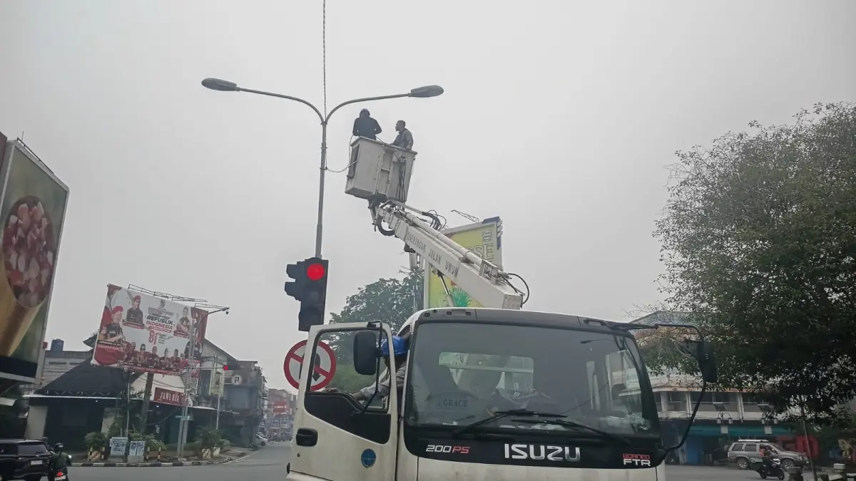Petugas Dishub Pontianak memperbaiki lampu lalu lintas yang sempat rusak akibat pencurian kabel.