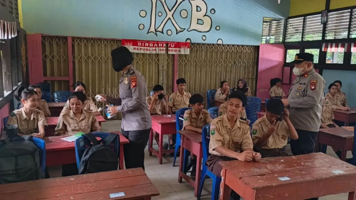 Kapolsek Kembayan Iptu Hudson Siahaan bersama personel Polsek Kembayan membagikan masker kepada siswa dan siswi SMP Negeri 1 Kembayan, Kecamatan Kembayan, Kamis (24/9). (ISTIMEWA)