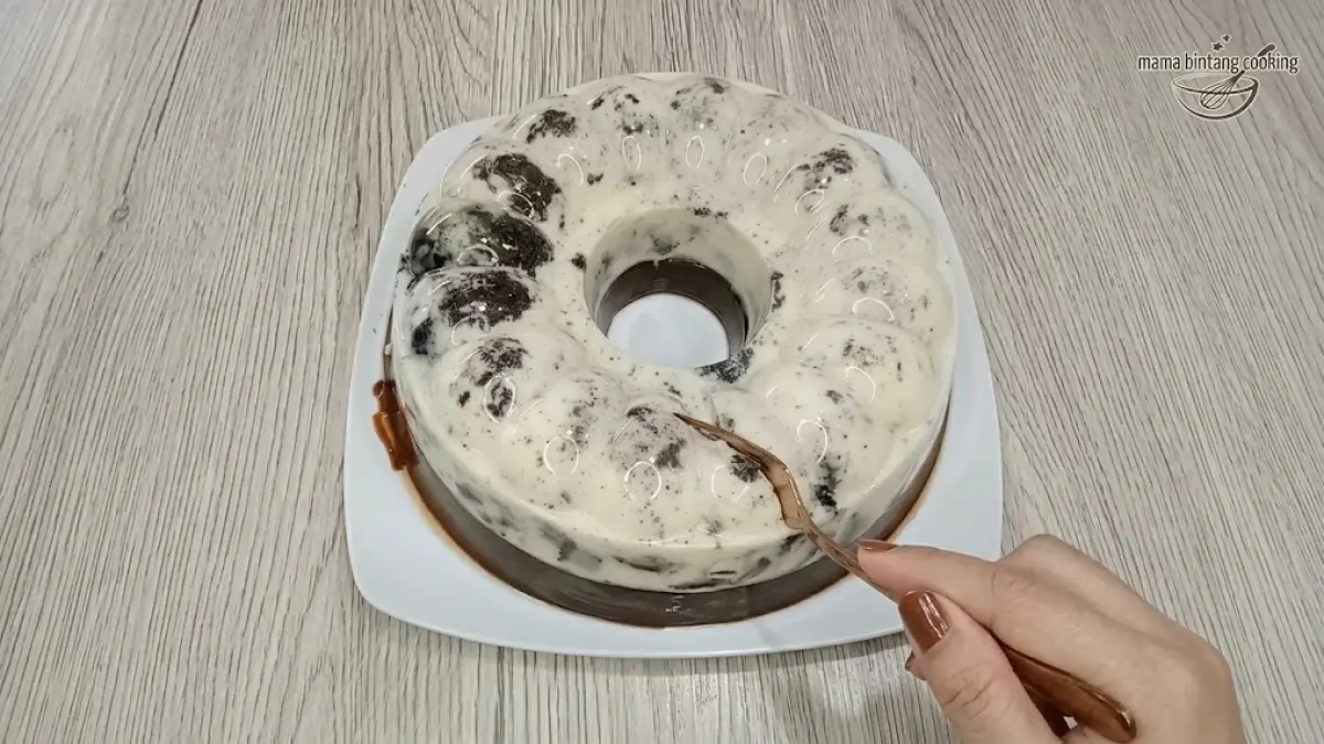 Puding Oreo cokelat dua lapis menjadi sajian manis dengan lapisan Oreo dan puding cokelat yang dingin.