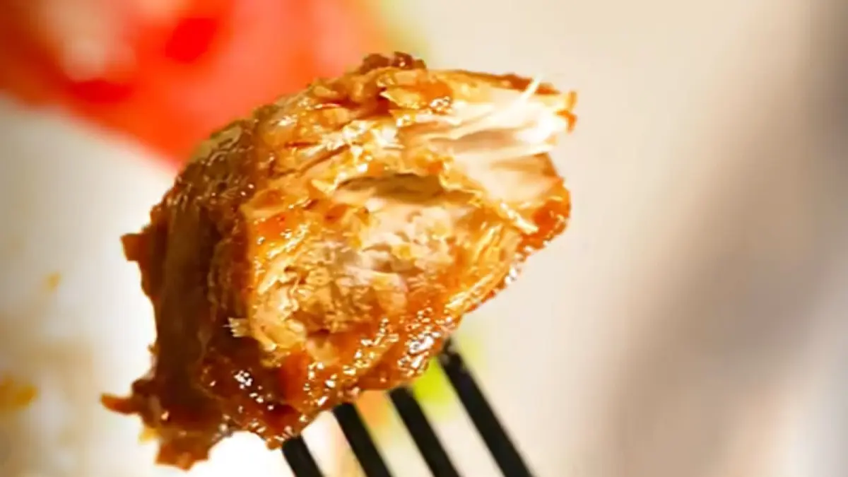 Ayam goreng disiram saus lada bersama bawang bombai, cabai, dan daun bawang hingga menghasilkan tampilan mengilap.
