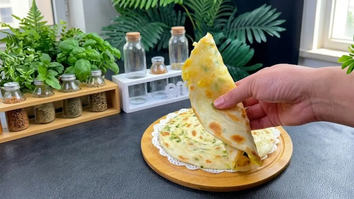 Ilustrasi sesuai video yang memperlihatkan roti maryam daun bawang dipanggang hingga bagian luar garing dengan bagian dalam lembut dan berlapis.