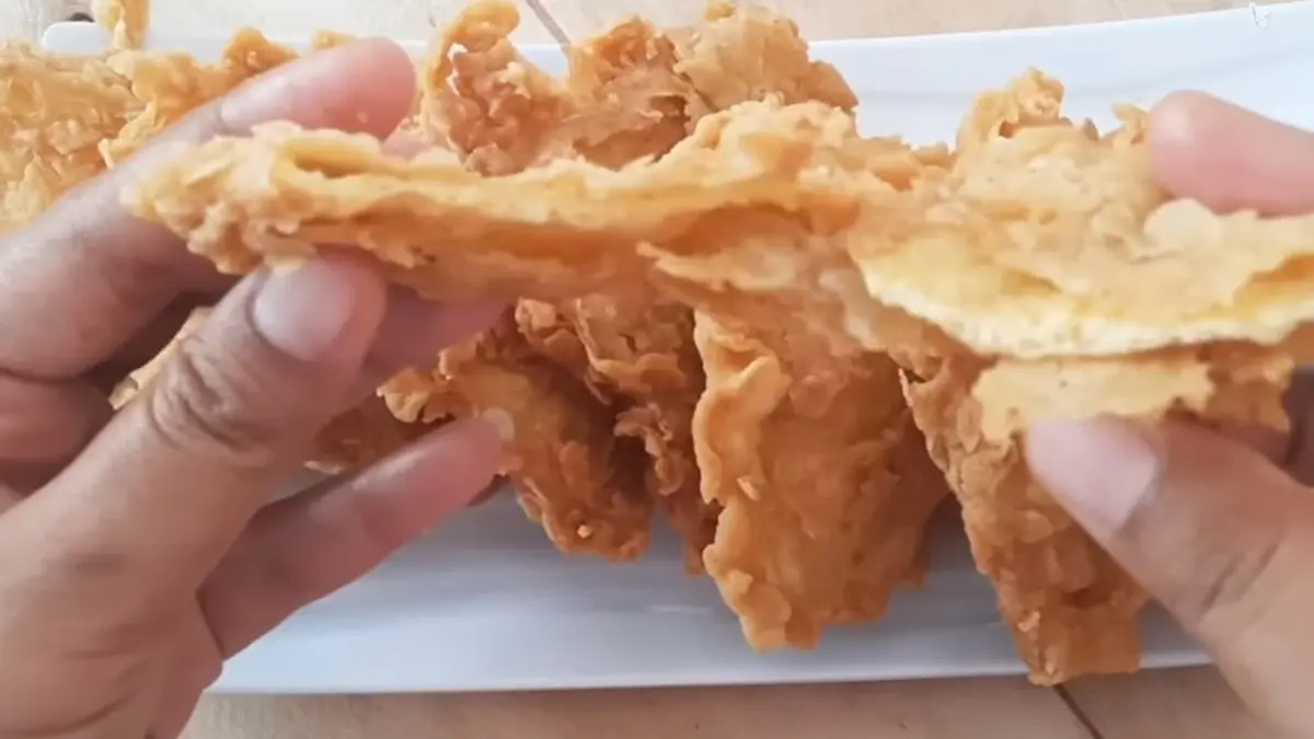 Telur dadar crispy digoreng kembali dengan lapisan tepung hingga permukaannya keriting dan garing.