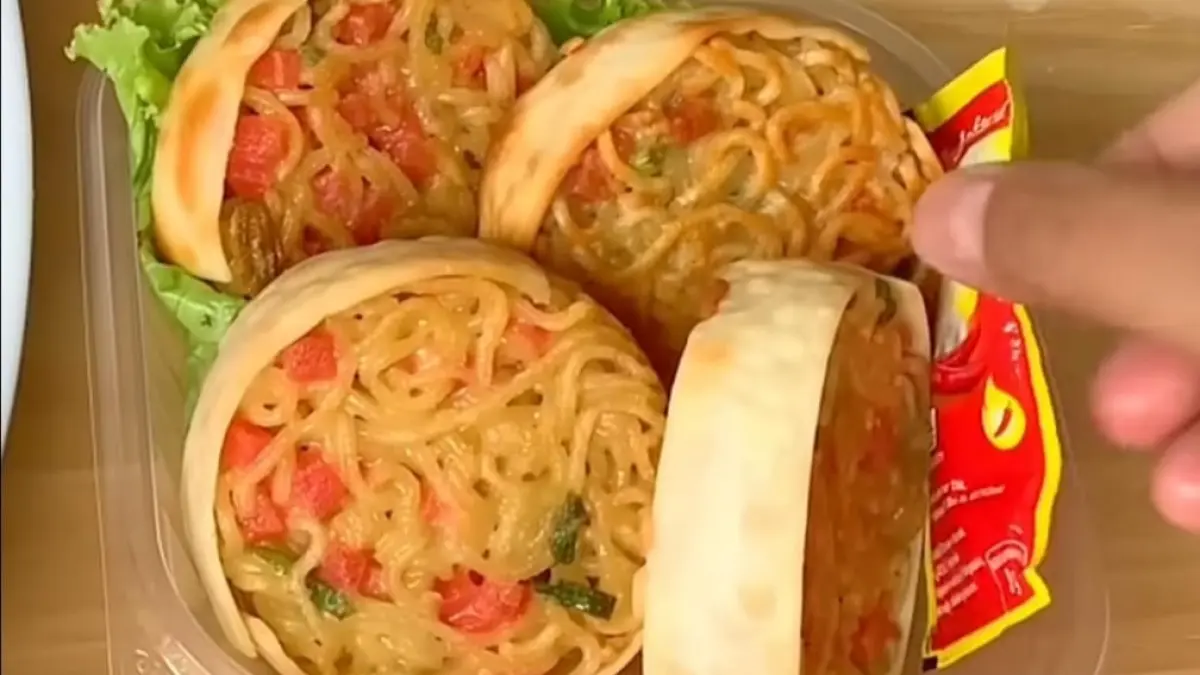 Martabak mie dengan kulit pangsit dan isian sosis, telur, serta daun bawang yang dimasak hingga kecokelatan.