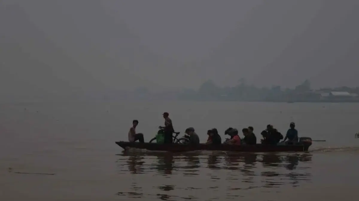 KABUT ASAP: Kabut asap menyelimuti perahu motor membawa penumpang di Sungai Kapuas, Kota Pontianak pada Kamis (8/10). Kualitas udara Kota Pontianak mencapai kategori berbahaya dengan AQI 439 dan konsentrasi PM2.5 sebesar 295 µg/m³ pada Jumat (9/10) pukul 22.00 WIB. Asap berpotensi berasal dari kebakaran lokal maupun terbawa angin dari wilayah lain. (FOTO JESSICA WUYSANG/ANTARA FOTO)