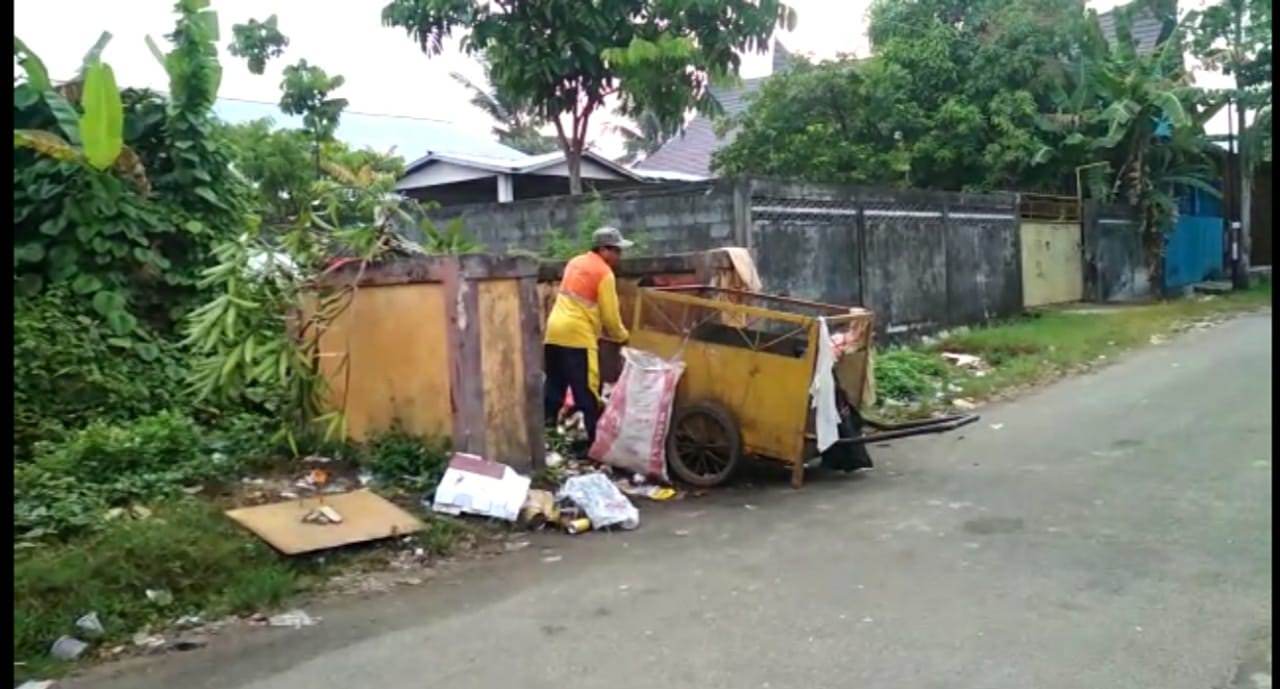 ANGKUT: Petugas kebersihan sedang mengangkut tumpukan sampah dari dalam TPS. Har/Pontianak Post 