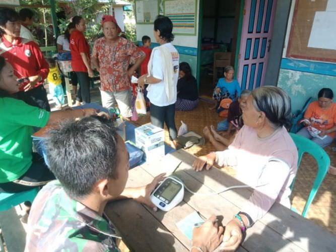 PERIKSA KESEHATAN: Satgas Pamtas Yonif Raider 301/Prabu Kian Santang Pos Klawik, saat melakukan pemeriksaan kesehatan kepada warga perbatasan. ISTIMEWA