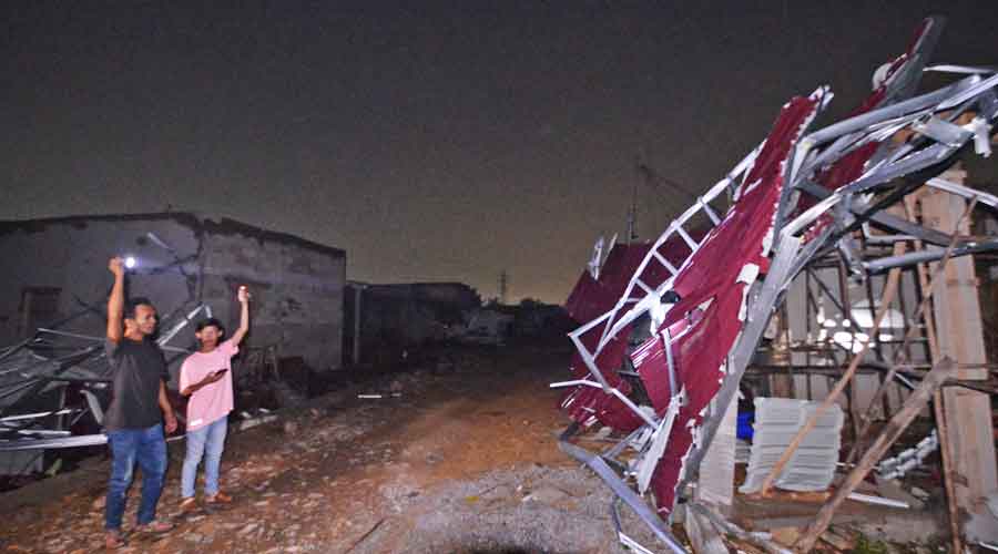 PUTING BELIUNG: Warga  sedang menunjukkan puing-puing bangunan yang roboh akibat diterjang puting beliung di Jalan Ampera Raya, Kabupaten Kubu Raya, Selasa (13/8) malam. MEIDY KHADAFI/PONTIANAK POST