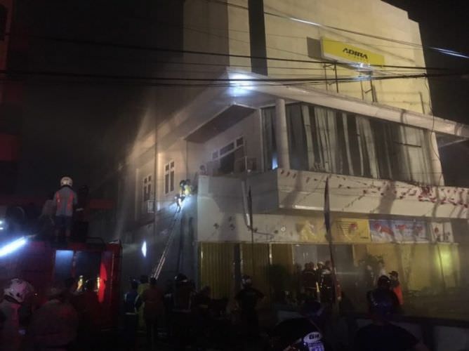 Berjibaku: Petugas pemadam kebakaran swasta di Kota Pontianak saat berjibaku memadamkan api yang membakar kantor Adira Finance, di Jalan KH Ahmad Dahlan, Minggu (18/8) pukul 19.30. SIGIT ADRIYANTO/PONTIANAK POST