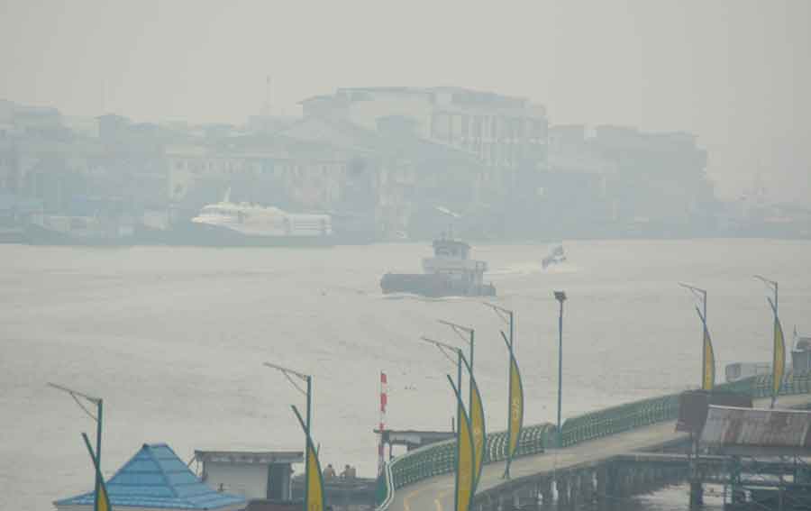 BERSELIMUT ASAP: Kondisi pusat Kota Pontianak pada kemarin siang. Kabut asap karhutla merata menutupi panorama di alur Sungai Kapuas serta pusat kota. MUJADI/PONTIANAK POST