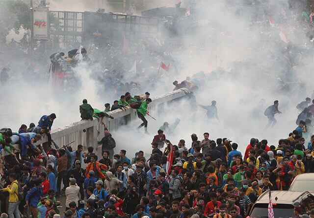 Ribuan mahasiswa yang menggelar aksi di depan gedung DPR-MPR, Jakarta, semburat saat polisi menembakkan gas air mata. Demo tersebut dilakukan untuk menolak sejumlah RUU kontroversial. (Muhamad Ali/Jawa Pos)