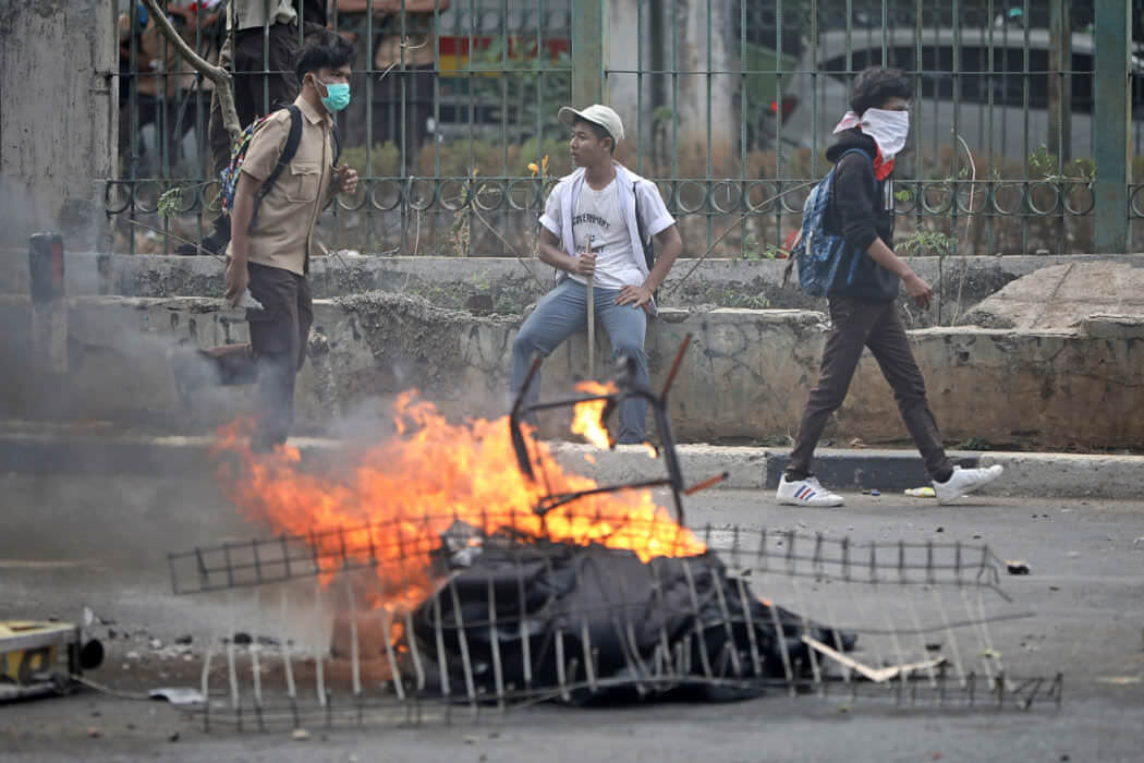 Puluhan pelajar berseragam SMP dan SMA melakukan aksi bakar-bakar dan lempar batu di belakang Gedung Parlemen, Senayan, Jakarta, Rabu (25/9/19). Tak ada spanduk berisi tuntutan aksi. FOTO: HENDRA EKA