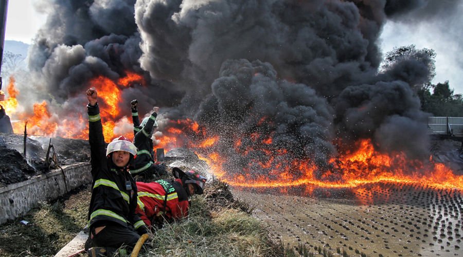 KEBAKARAN: Petugas pemadam kebakaran berusaha memadamkan api saat kebakaran pipa minyak milik PT. Pertamina di Melong, Kota Cimahi, Selasa, (22/10). PT.Pertamina masih melakukan invetigasi terkait kebakaran pipa milik pertamina tersebut yang terjadi di lo