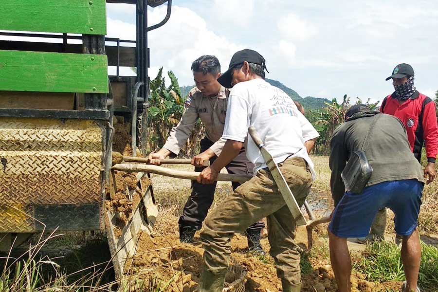 PERBAIKI: Warga Desa Kampet dibantu Bhabinkamtibmas setempat bergotong royong memperbaiki jalan rusak, akhir pekan lalu. ISTIMEWA