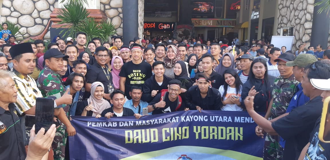 FOTO BERSAMA: Daud Yordan berfoto bersama Bupati Kayong Utara Citra Duani serta mahasiswa Kayong Utara di Malang, Jawa Timur, berfoto bersama usai berhasil menyaksikan kemenangan TKO Cino menganvaskan Michael Mokoena. ISTIMEWA