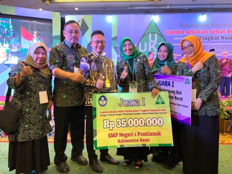 Wali Kota Edi Kamtono memegang piala SMP 1 yang menjuarai Lomba Sekolah Sehat.