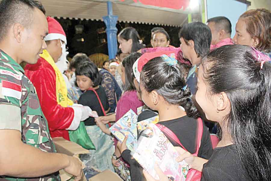 BAGI KADO: Satgas Pamtas Yonif Raider 641/Beruang, Pos Kout Jagoi Babang membagikan kado Natal kepada anak-anak berupa Alkitab, alat dan buku tulis.