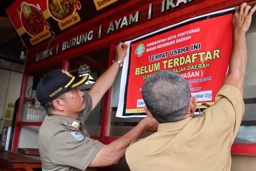 PERINGATAN: Petugas Pol PP dan BKD Pontianak memberi peringatan pada tempat usaha yang belum membayar pajak.  MIRZA/PONTIANAKPOST 