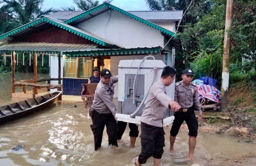 Warga dibantu personel Polsek Air Besar menyelamatkan barang-barang berharga dari terjangan banjir, Kamis (19/12). Foto Istimewa